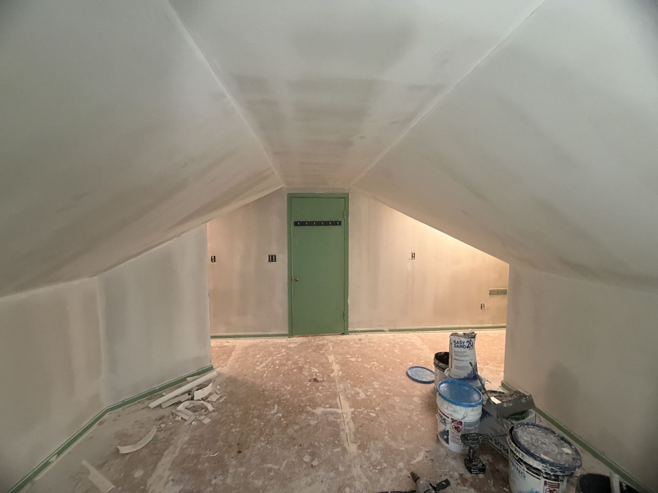 Drywall finish work on an angled ceiling and knee walls